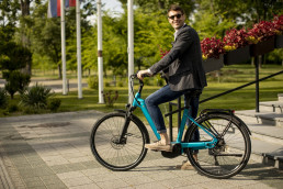 Handosme young businessman on the ebike at the street